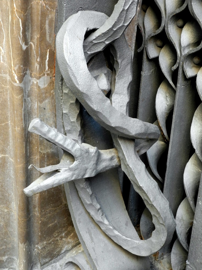Detalle de una serpiente en la puerta de entrada al Palau
